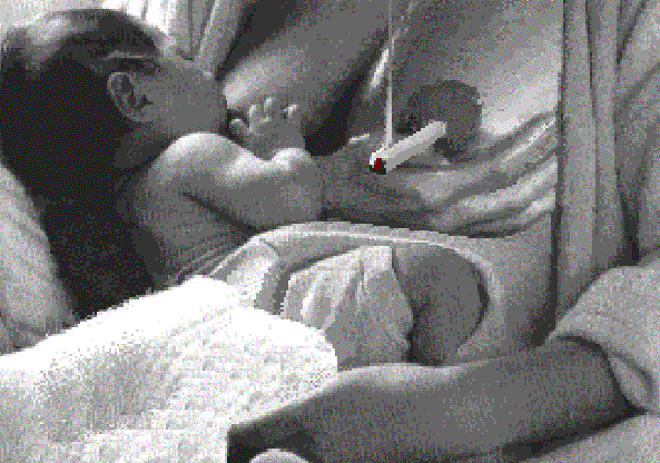 Dessin animé d'une jeune maman donnant la tétée, où l'on voit la nicotine passer de la cigarette à la bouche de bébé. Commentaire Tobacostop : Au secours, la nicotine passe dans mon lait : Allo, SOS mes deux seins...