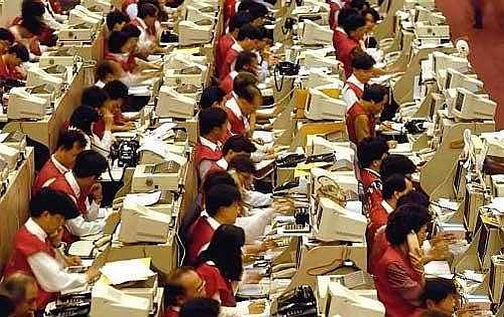 Photo d'une salle où sont alignés devant des écrans informatiques des rangées de dizaines de travailleurs dans le même costume rouge. Commentaire Tobacostop : Fléchis par le tabac, courbés sous le travail, les fumeurs salariés se retrouvent doublement en ployés...
